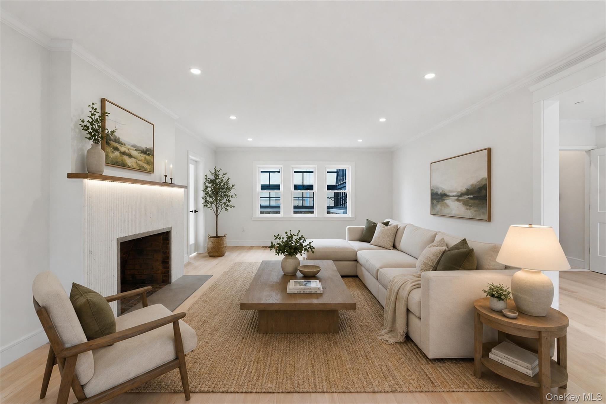 40 Calhoun Avenue New Rochelle, NY 10801 - Photo 11 of 49 Living area featuring a textured white fireplace with a wood mantle and integrated lighting, light wood-finish flooring, recessed lighting, and multiple windows