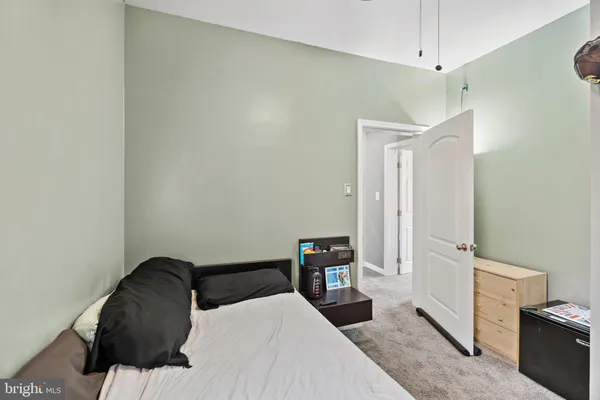 a hallway with hardwood floor and a large mirror