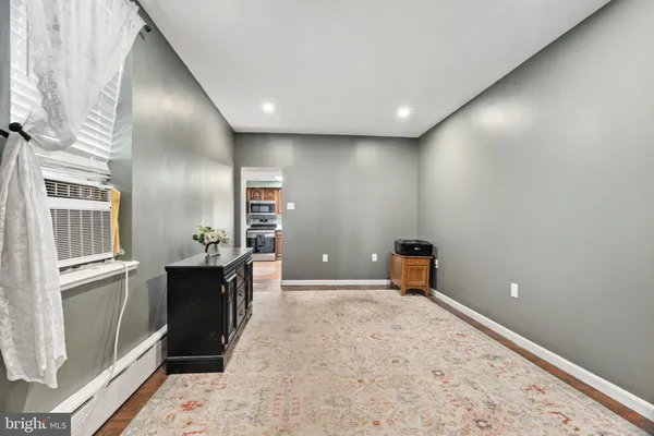 a kitchen with stainless steel appliances granite countertop a refrigerator a stove a sink a microwave a dining table and chairs with wooden floor
