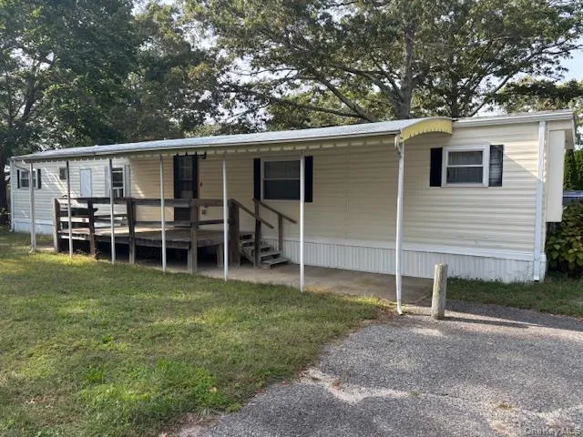 a view of a backyard with table and chairs and barbeque grill with wooden fence