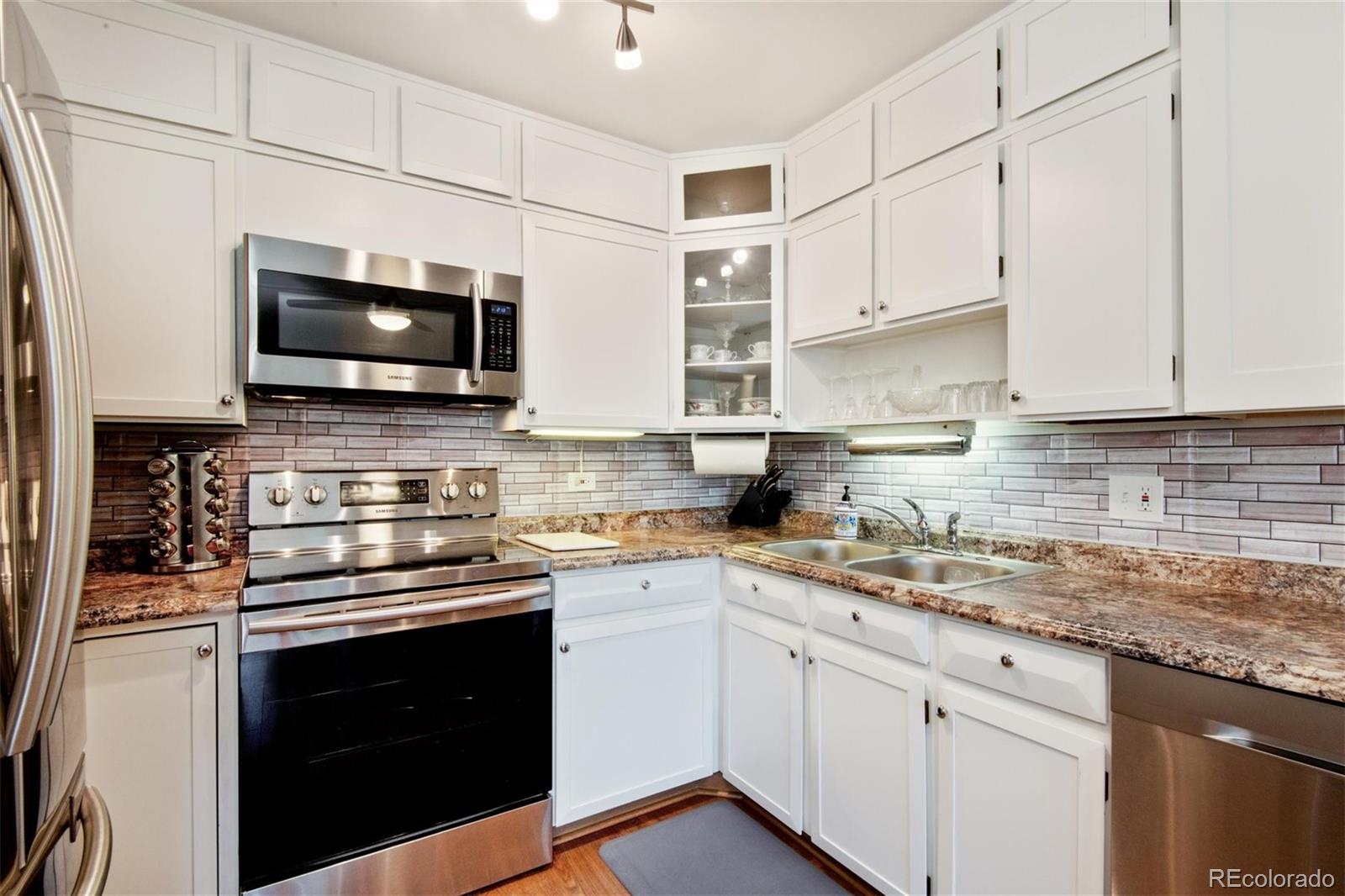 a kitchen with stainless steel appliances granite countertop a sink a stove and microwave