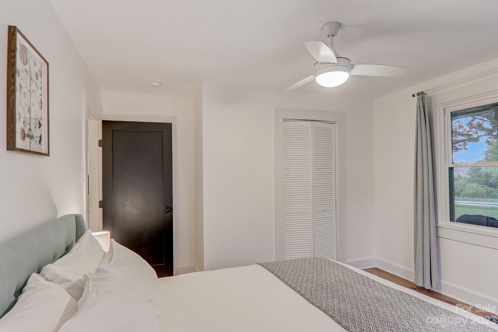 290 Upper Brush Creek Road Fletcher, NC 28732 - Photo 23 of 48 a bedroom with a bed and a chandelier