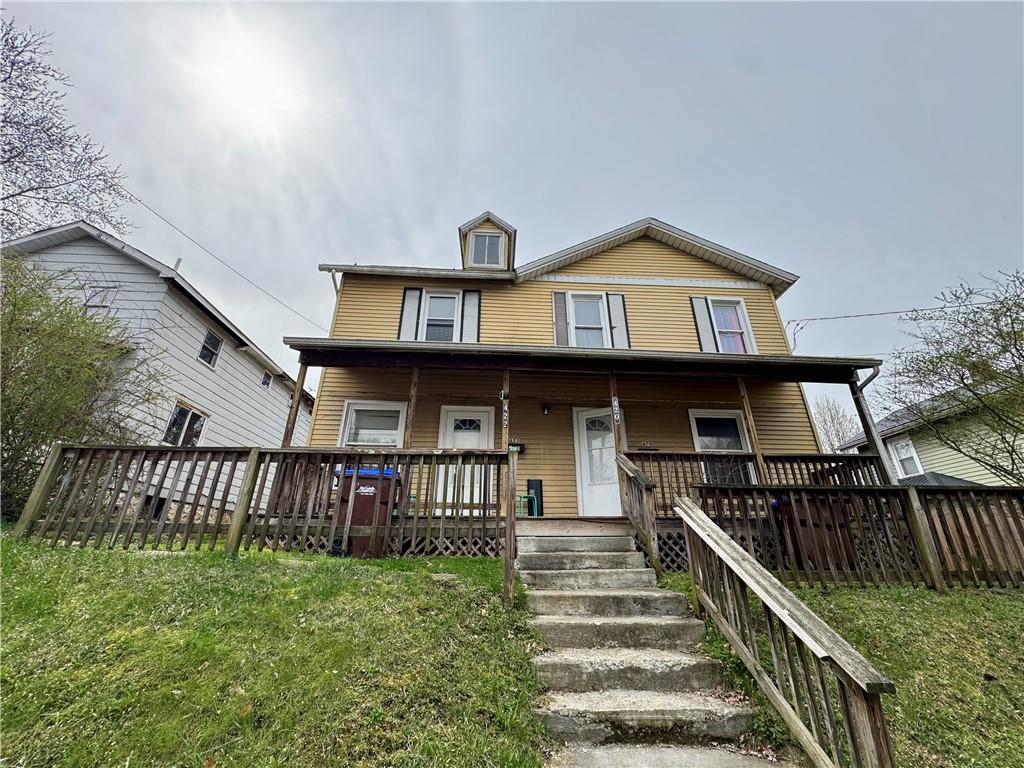 a view of a house with wooden stairs and a fence