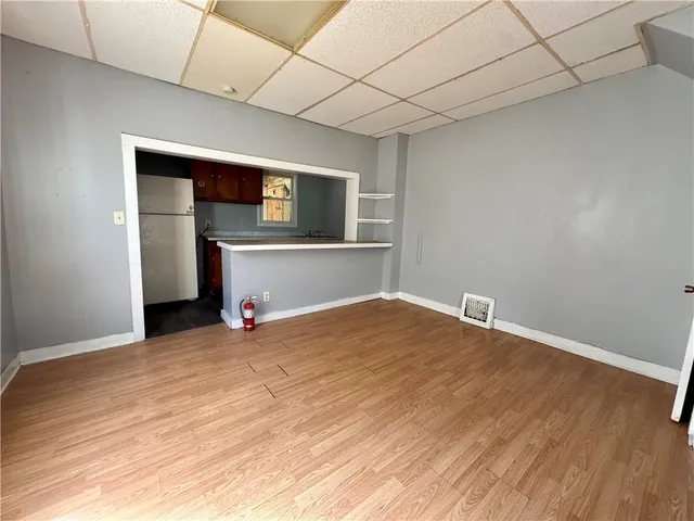 a view of empty room with wooden floor and fireplace