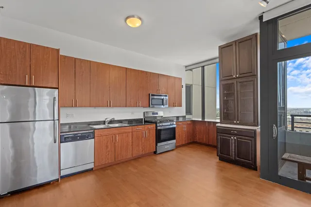a kitchen with stainless steel appliances granite countertop a refrigerator stove and sink