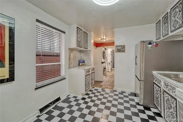 a room with a black white checkered floor and a large window