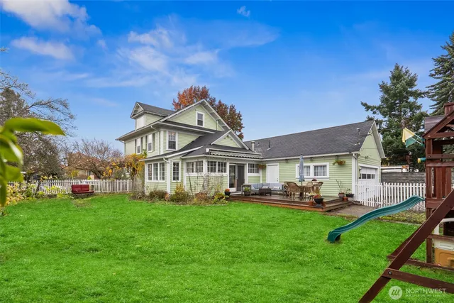 a front view of a house with garden and trees