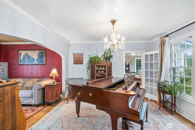 a living room with furniture a chandelier and a dining table