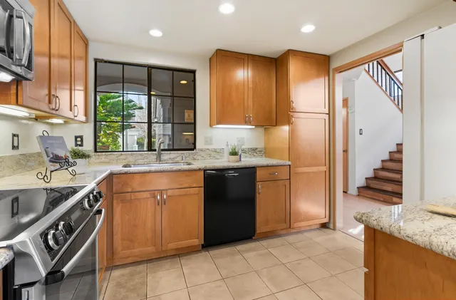 a kitchen with stainless steel appliances granite countertop a sink and a refrigerator