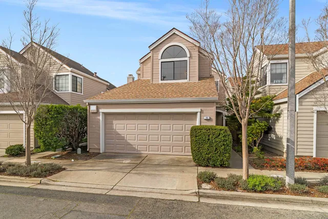a front view of a house with a garden and garage