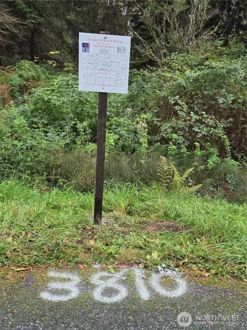 a sign that is sitting in front of a tree