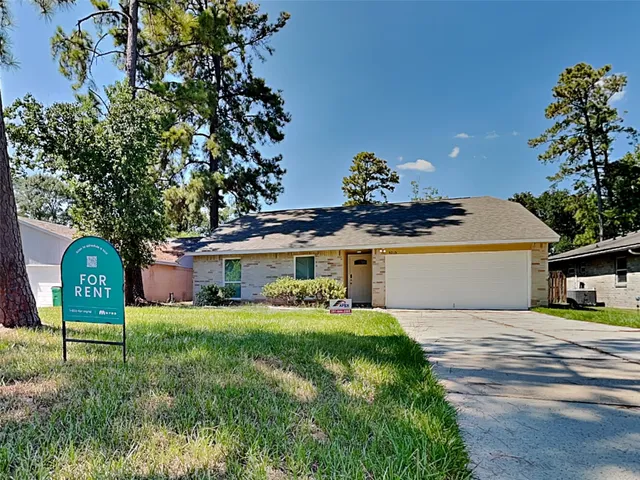 a front view of a house with a garden and trees