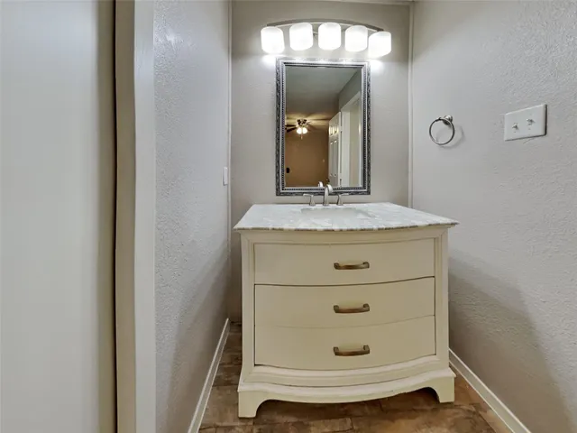 a bathroom with a granite countertop toilet a sink and a mirror
