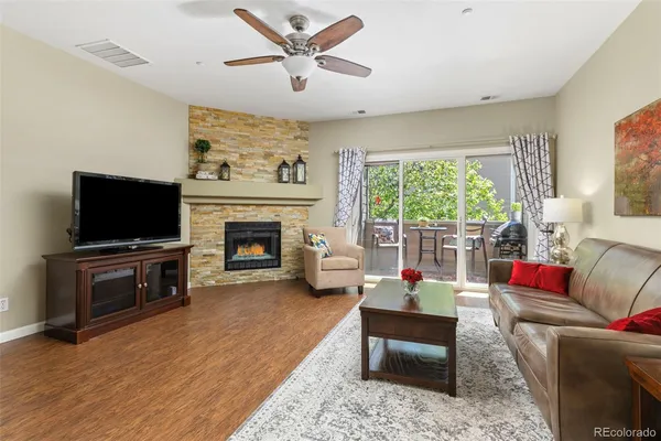 a living room with furniture a flat screen tv and a fireplace