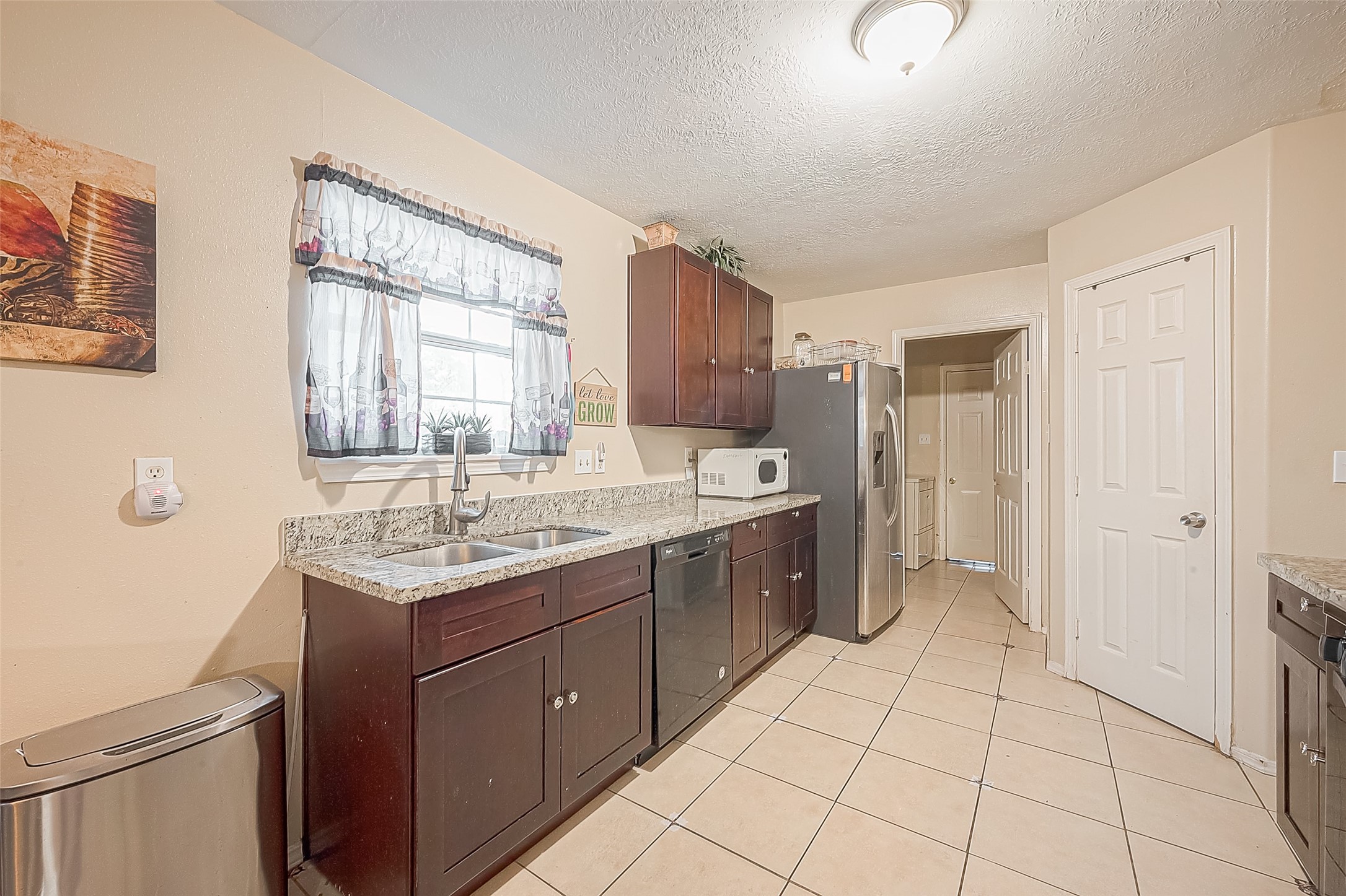 944 Dewalt Street Houston, TX 77088 - Photo 9 of 17 a kitchen with a sink a refrigerator and cabinets