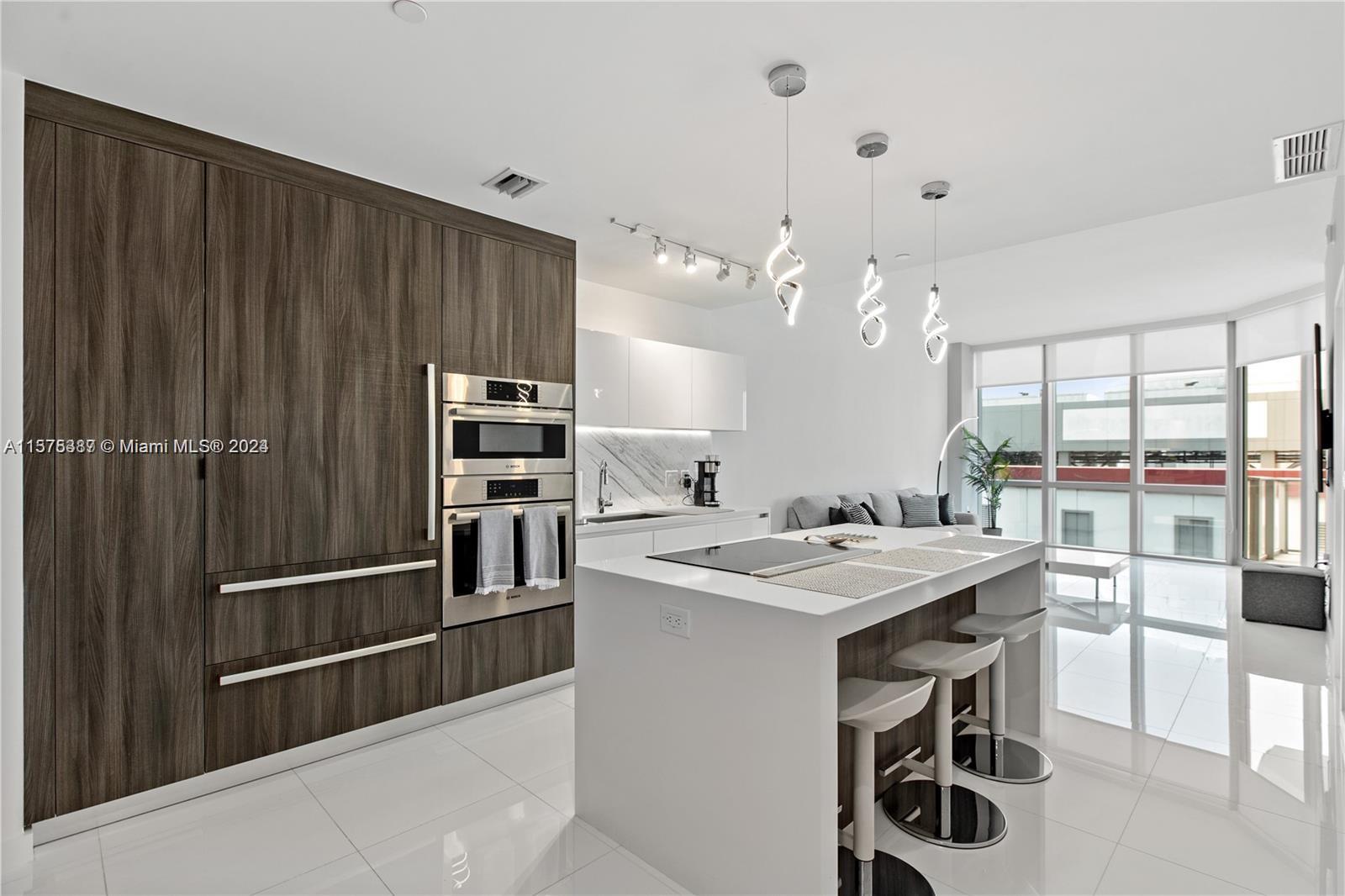 a kitchen that has a kitchen island wooden cabinets and stainless steel appliances