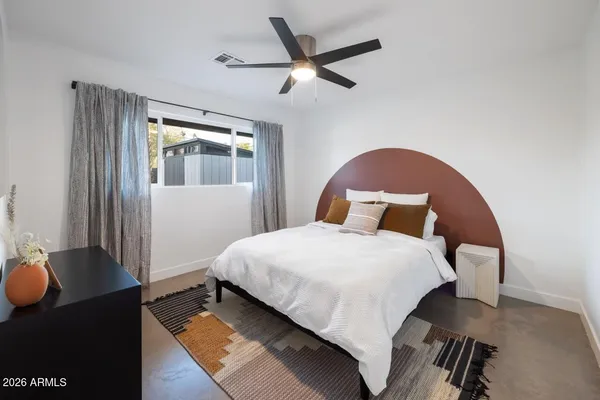 a bedroom with a bed and wooden floor