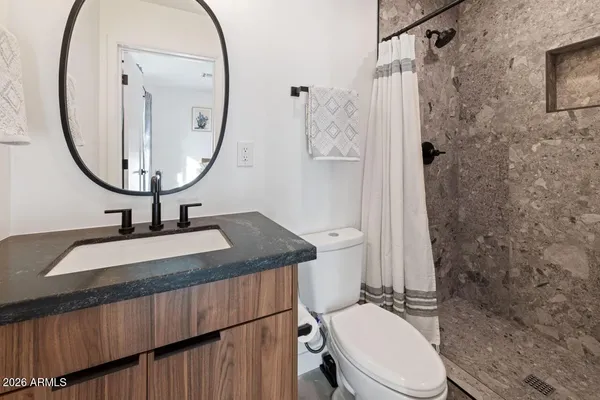 a bathroom with a sink a toilet and a mirror