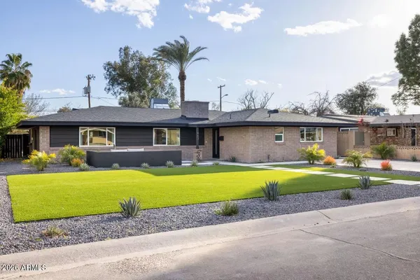 a front view of a house with a yard and swimming pool