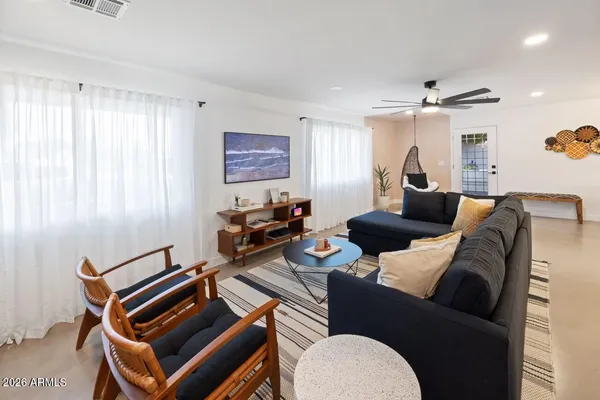 a living room with furniture a ceiling fan and a window