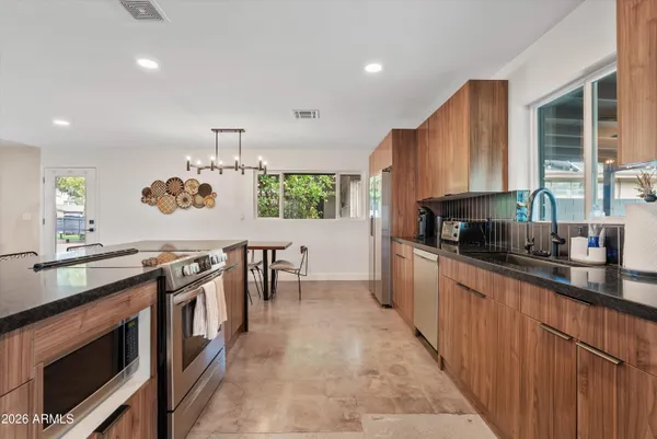 a kitchen with kitchen island granite countertop lots of counter top space and stainless steel appliances