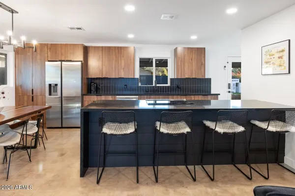 a kitchen with a sink and chairs