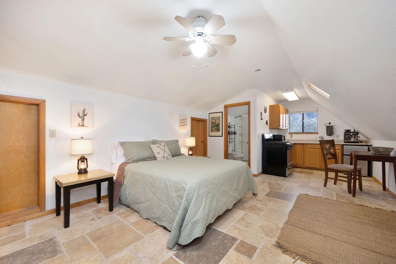 5501 Scott Road Sloughhouse, CA 95683 - Photo 61 of 87 a spacious bedroom with a bed and a chandelier