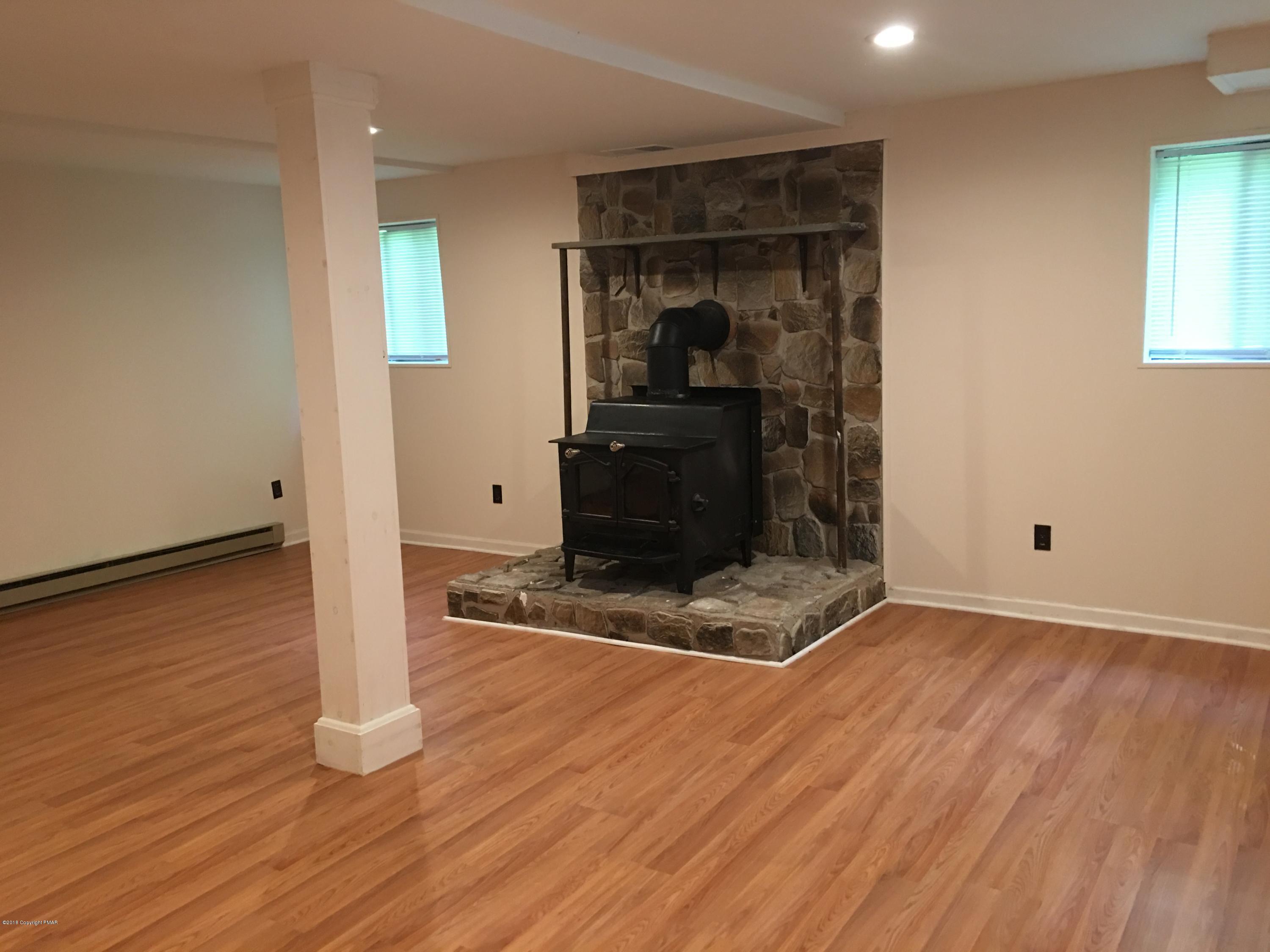 35 Kensington Road Hawley, PA 18428 - Photo 15 of 21 an empty room with wooden floor a fireplace and windows