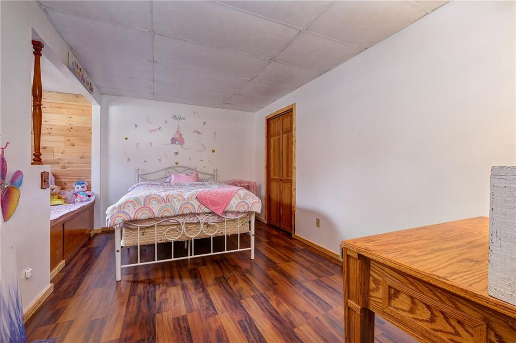 4249 Hollow Road New Castle, PA 16101 - Photo 20 of 33 a bedroom with a bed next to a large window with wooden floor