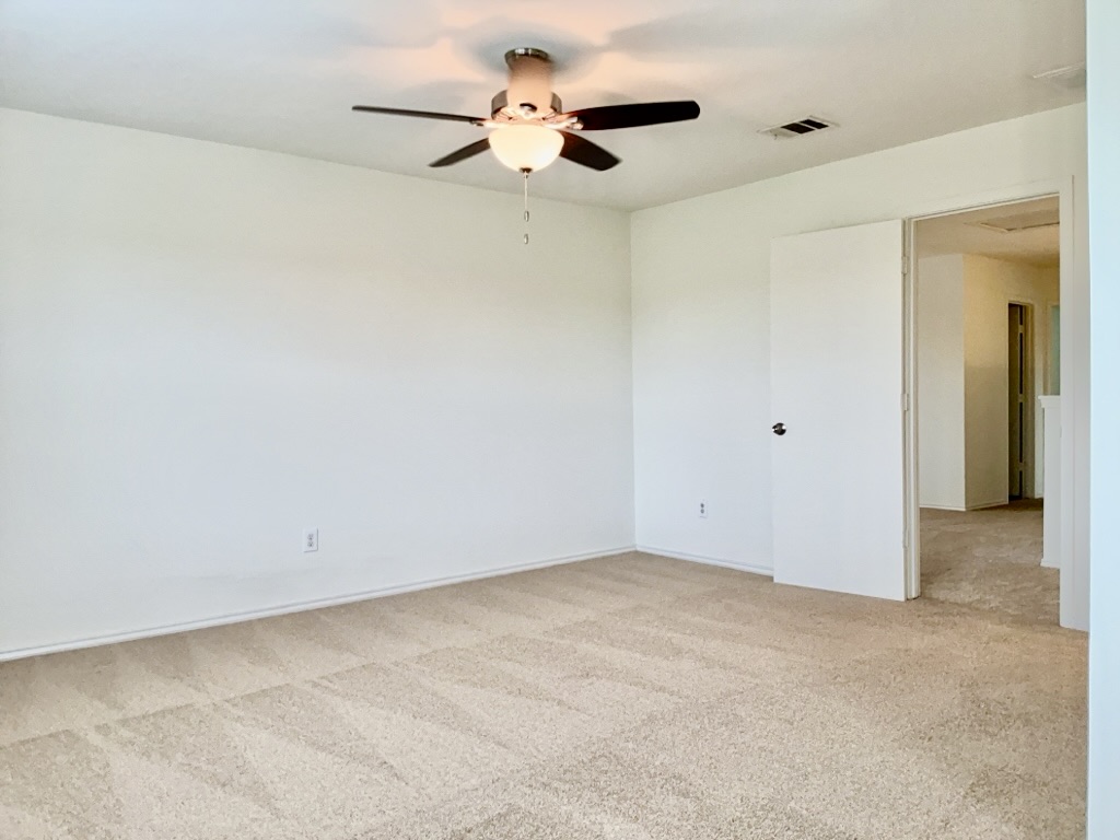 2242 Perkins Place Georgetown, TX 78626 - Photo 12 of 25 Spacious room featuring neutral carpeting, a ceiling fan with integrated lighting, and a white interior door