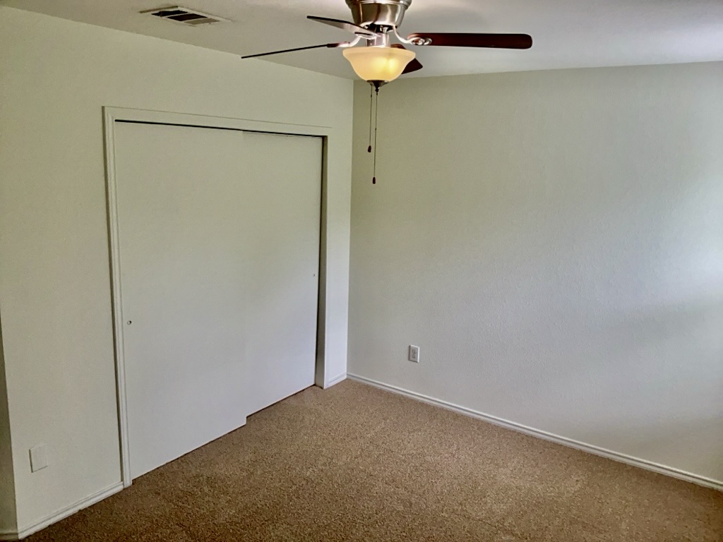 2242 Perkins Place Georgetown, TX 78626 - Photo 21 of 25 Wall-to-wall carpeting in a neutral tone, complemented by a ceiling fan with integrated lighting