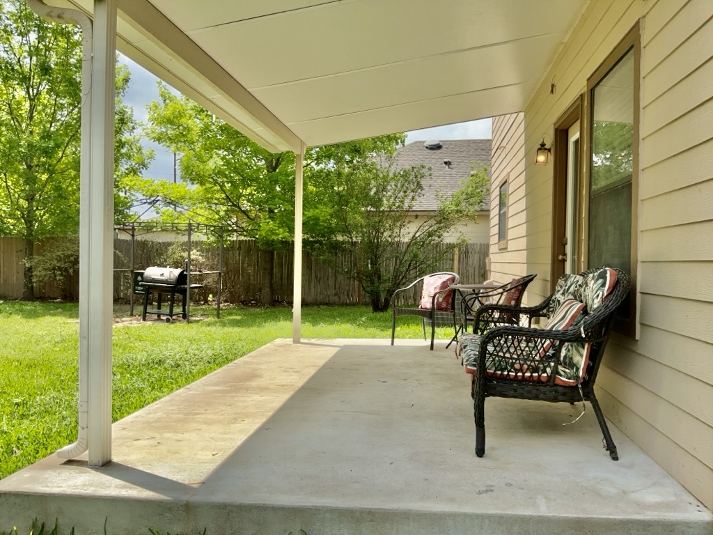 2242 Perkins Place Georgetown, TX 78626 - Photo 23 of 25 Covered concrete patio extending to a grass backyard with a wood fence perimeter