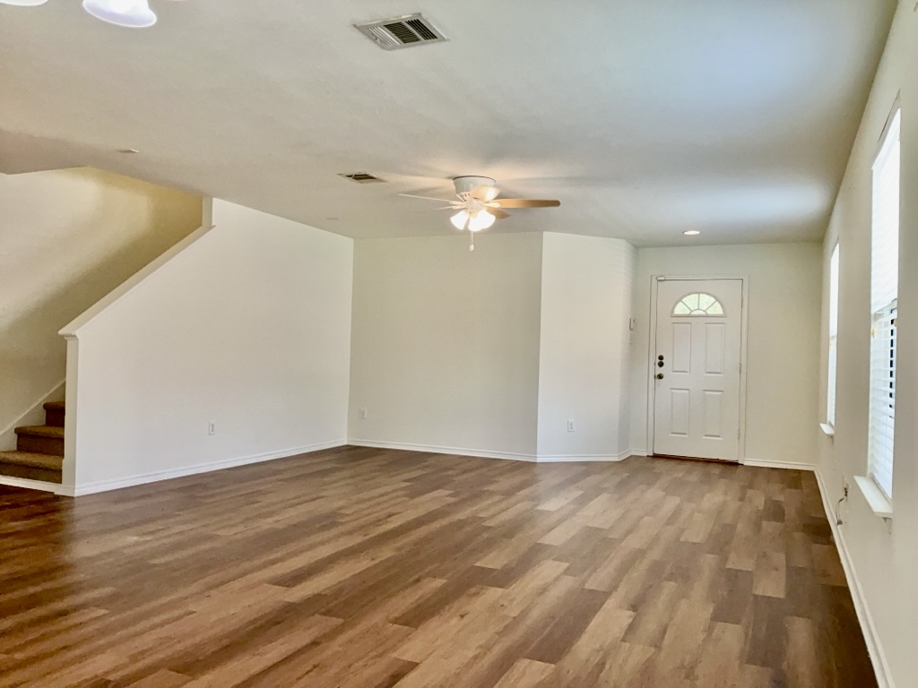 2242 Perkins Place Georgetown, TX 78626 - Photo 3 of 25 Spacious living area featuring wood-finish flooring, white walls, and a ceiling fan with light fixture