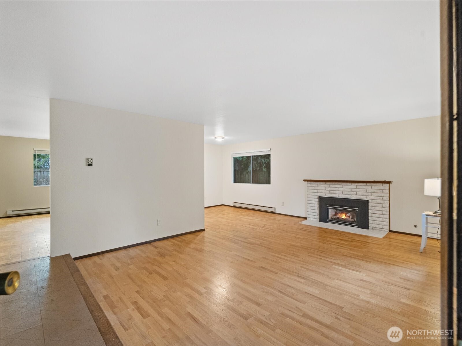 8506 192nd Street Southwest Edmonds, WA 98026 - Photo 6 of 37 an empty room with wooden floor fireplace and windows