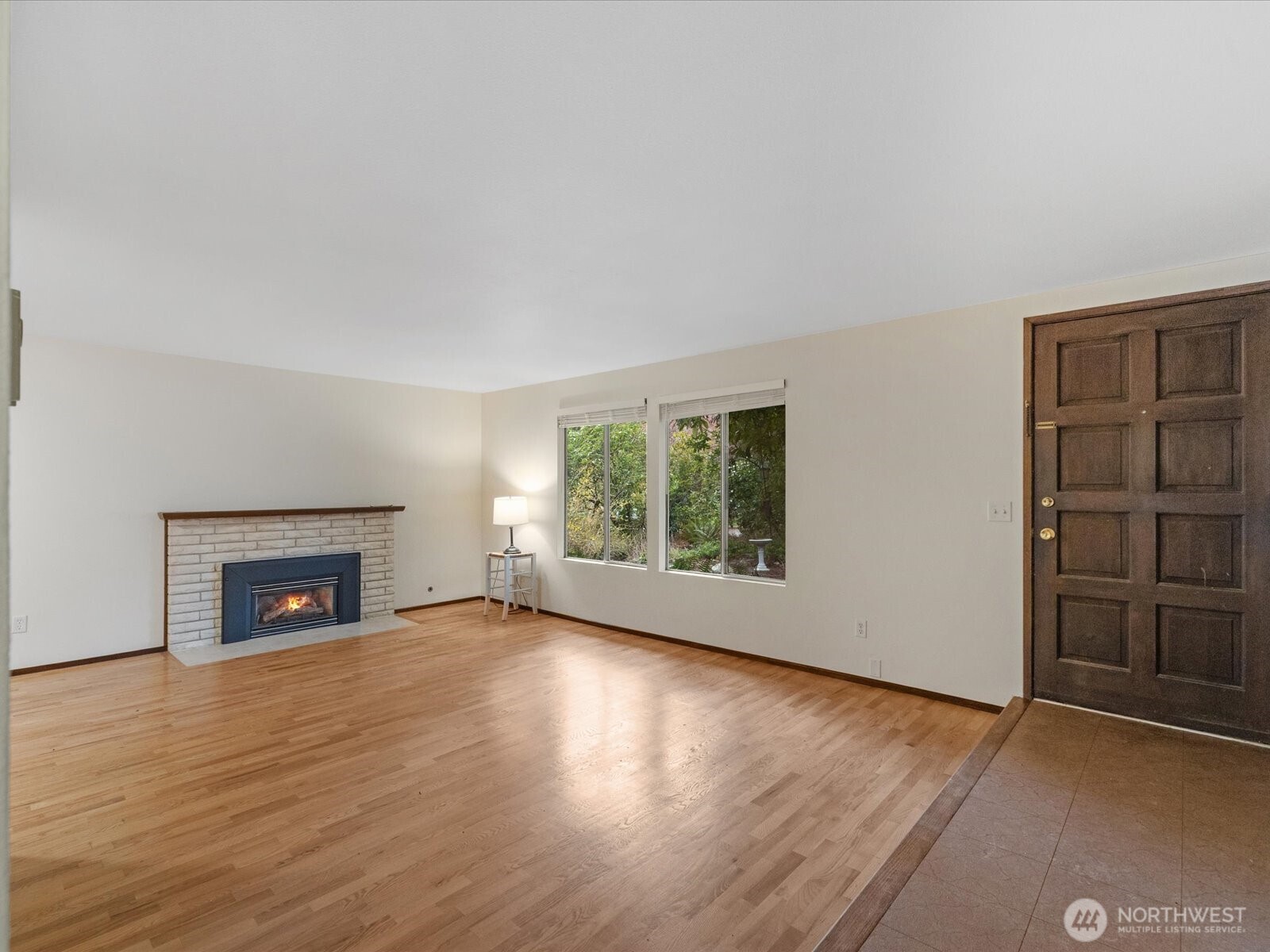 8506 192nd Street Southwest Edmonds, WA 98026 - Photo 10 of 37 an empty room with windows a fireplace and wooden floor