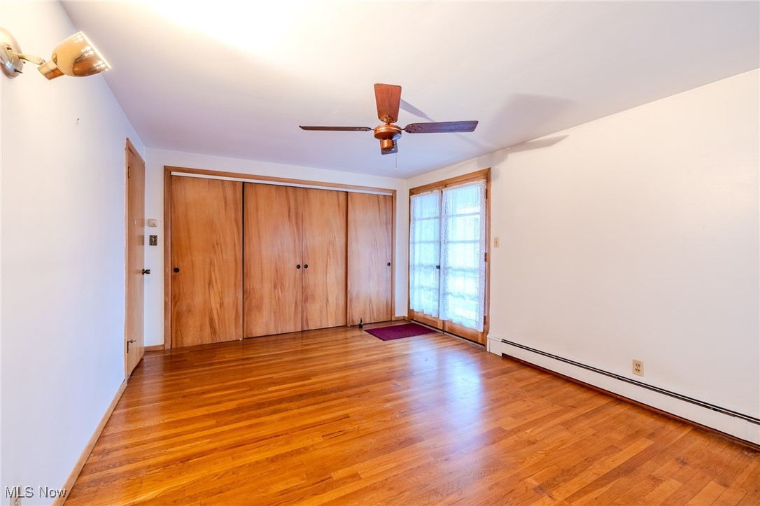 1950 Rush Road Wickliffe, OH 44092 - Photo 10 of 50 Unfurnished bedroom with light wood finished floors, a baseboard radiator, a closet, and a ceiling fan