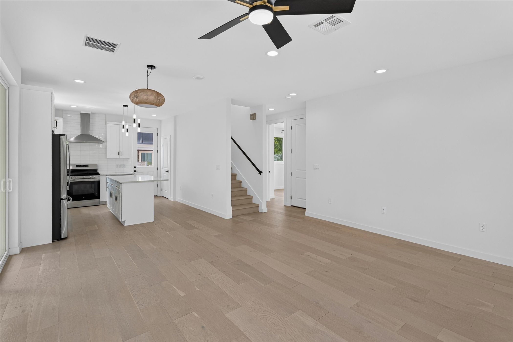5305 Ledesma Road, Unit 1 Austin, TX 78721 - Photo 8 of 29 An open-concept living area with light wood flooring seamlessly connects the kitchen and provides access to a contemporary staircase.