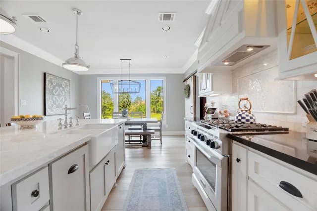 a kitchen with stainless steel appliances granite countertop a sink stove and cabinets