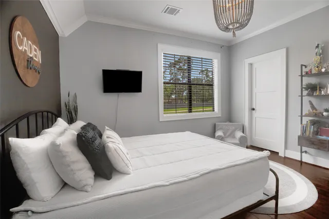 a bedroom with a bed a mirror and a window