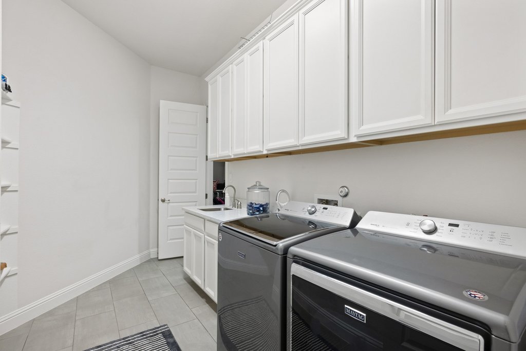 215 Lodestone Lane Austin, TX 78738 - Photo 24 of 40 Streamlined laundry room with ample storage cabinetry and a convenient utility sink.