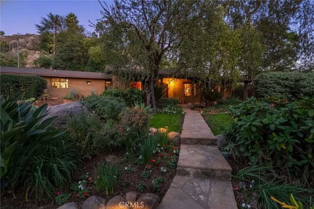 a front view of house with a yard and trees