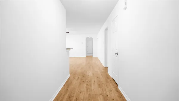 a view of a hallway with wooden floor