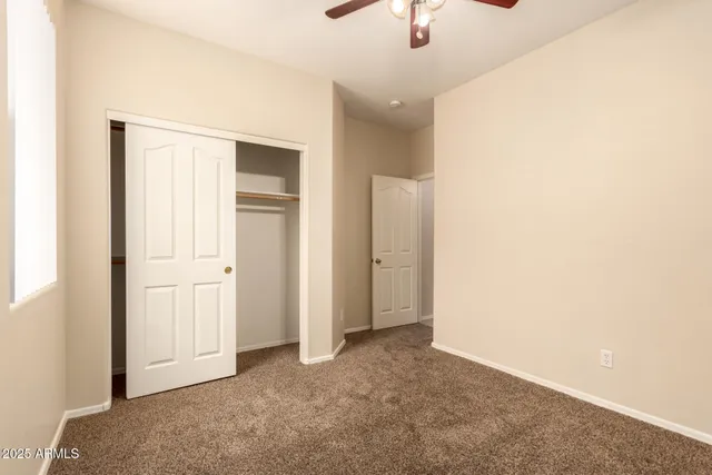 an empty room with closet and windows