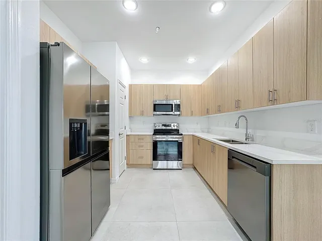 a kitchen with granite countertop a refrigerator and a sink