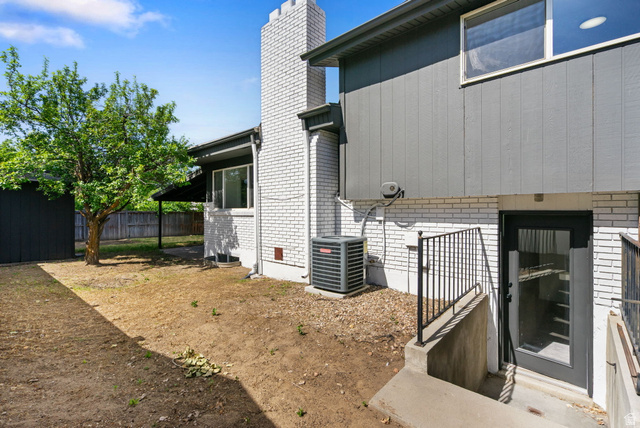 432 Calnette Drive Sandy, UT 84070 - Photo 39 of 48 Rear exterior featuring a full light glass door, black metal handrails, white brick facade, and gray vertical siding