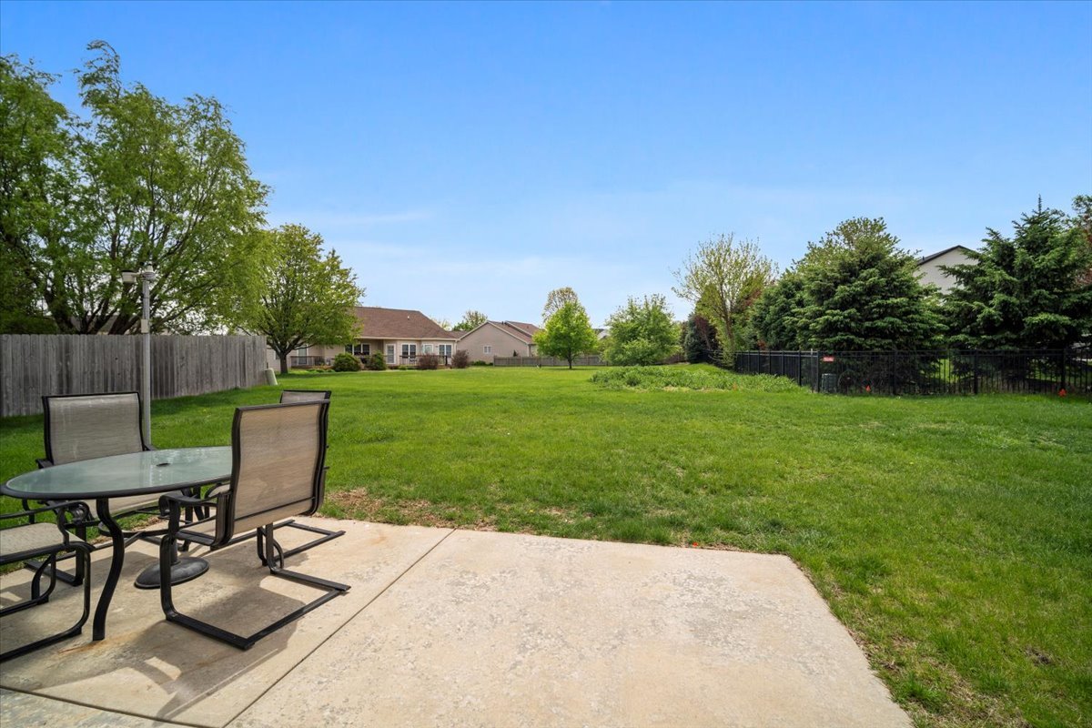 2321 Corrigan Way Normal, IL 61761 - Photo 31 of 33 a view of a backyard with table and chairs and potted plants with wooden fence