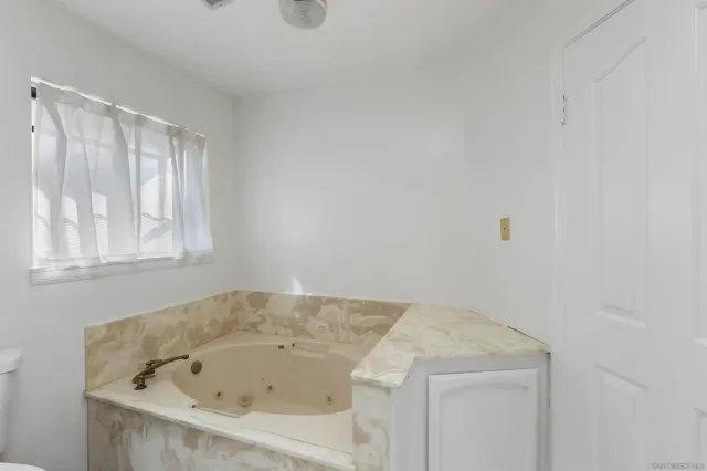 a bathroom with a tub and window