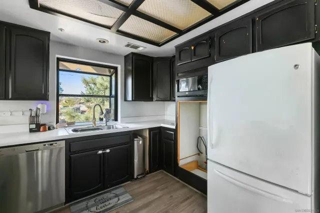 a kitchen with a sink a refrigerator and window