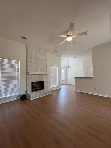 a view of empty room with wooden floor and fireplace