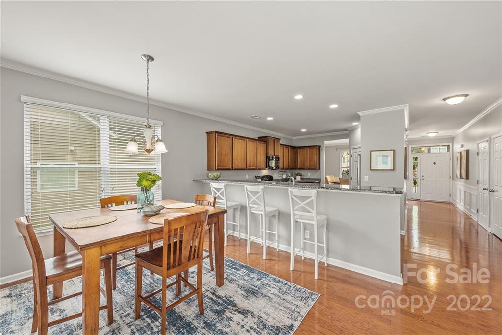 116 Annatto Way Tega Cay, SC 29708 - Photo 12 of 36 a view of a dining room and livingroom with furniture wooden floor a rug and a chandelier